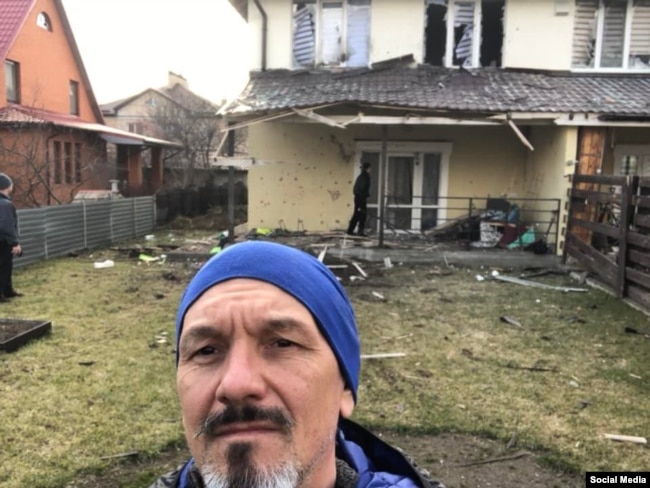 Роман Власенко на тлі свого обстріляного російськими військовими будинку у Ворзелі